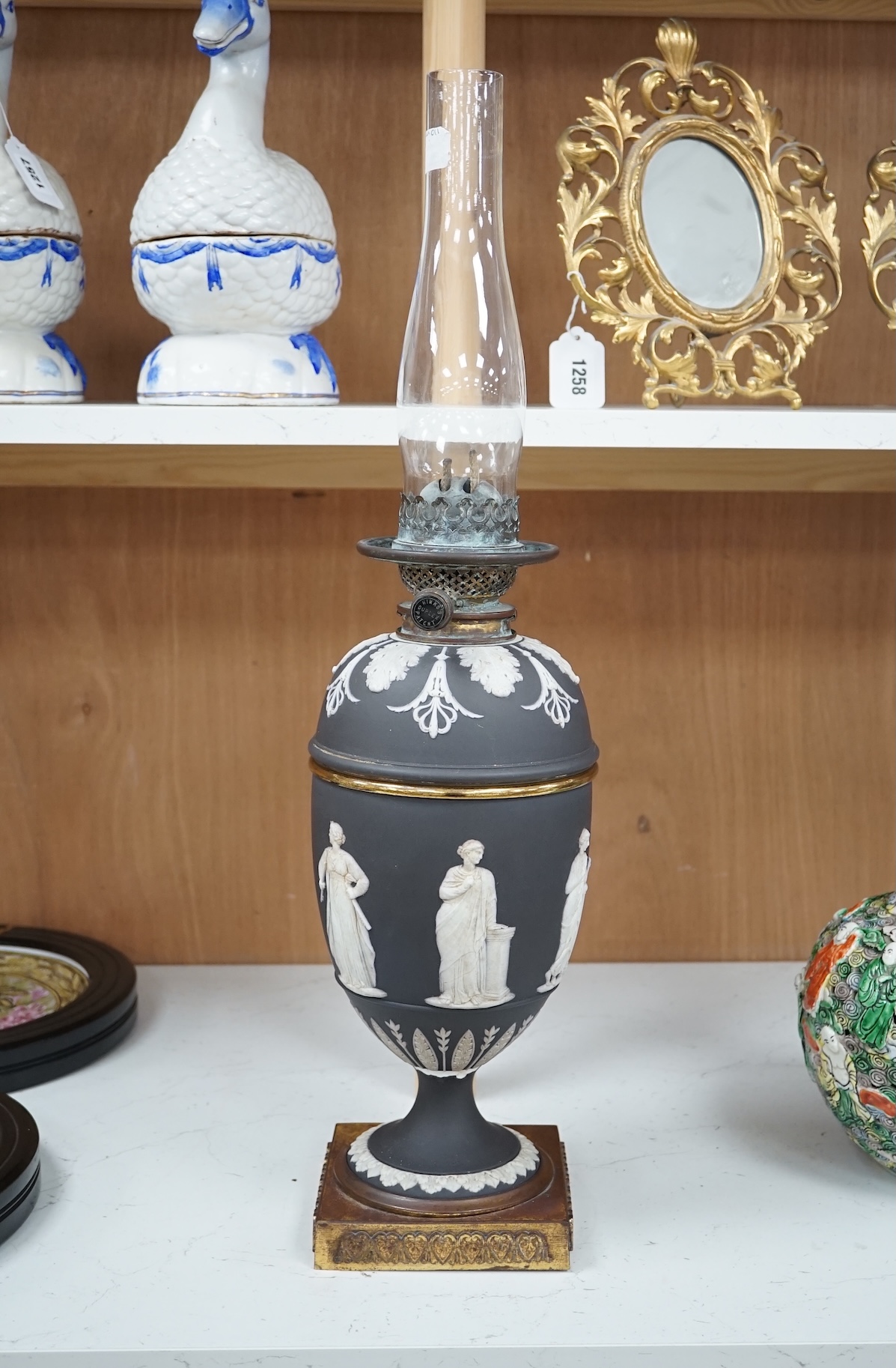 A Victorian black jasper oil lamp and reservoir, 65cm high. Condition - repaired at stem